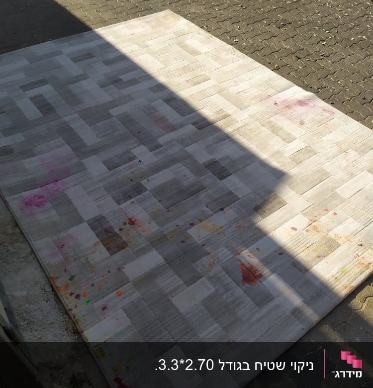 שטיח עם כתמים צבעוניים על רצפת אבן